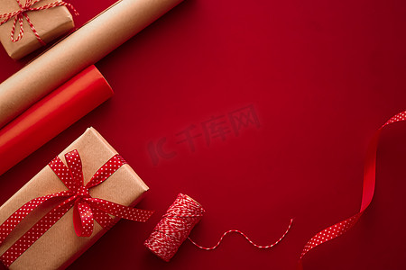 礼品准备、生日和节日礼物赠送、工艺纸和红色背景礼盒丝带作为包装工具和装饰品、DIY 礼物作为节日平躺设计