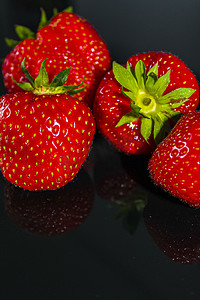 草莓与高贵的黑色背景玻璃桌德国。