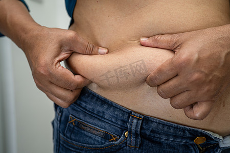超重的亚洲女性在办公室表现出肥胖的腹部。
