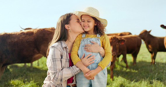 在西班牙度假期间，为了牛的可持续发展，农场、孩子和母亲亲吻农场。