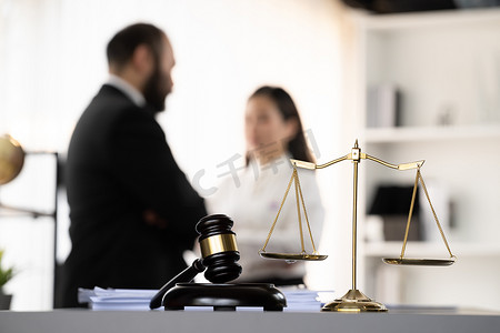 将法律符号聚焦在模糊的律师背景上。