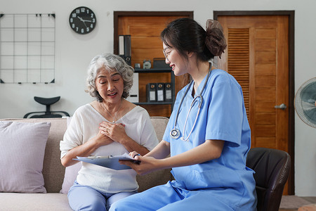 护士照顾病人摄影照片_在家照顾病人或老人的亚洲年轻护士。