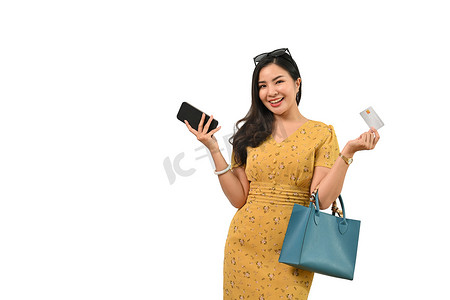 白色背景中手持信用卡和手机的快乐亚洲年轻女性肖像