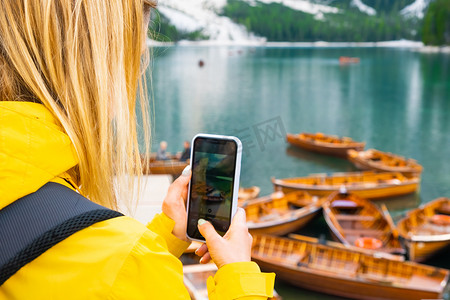 旅游博主和游客在多洛米蒂阿尔卑斯山的 Braies 湖上为船只拍照。