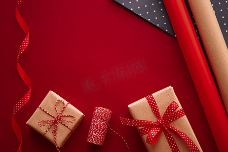 红色背景礼物礼盒摄影照片_礼品准备、生日和节日礼物赠送、工艺纸和红色背景礼盒丝带作为包装工具和装饰品、DIY 礼物作为节日平躺设计