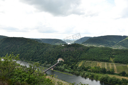 德国摩泽尔河环线上一座桥的鸟瞰图，周围环绕着绿树和葡萄园