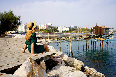 提耶利亚厄迪摄影照片_意大利莫利塞 Termoli 村坐在海滨的旅游妇女用 trabucco 传统捕鱼机放松