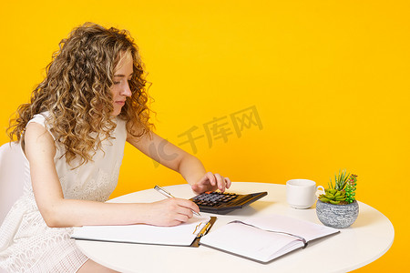 一名年轻女子坐在桌旁，处理文件，思考，研究。