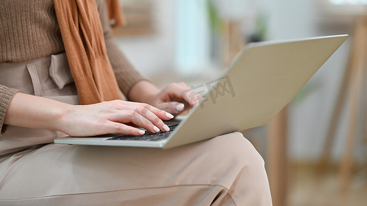 女性手在笔记本电脑上打字、远程学习或浏览互联网的裁剪图像