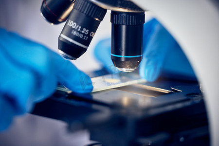 在科学或化学实验室工作的显微镜、细菌或手，用于未来的医疗保健创新。