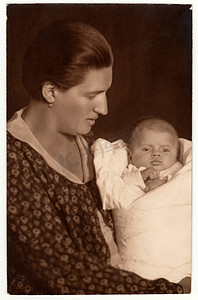 襁褓摄影照片_老式照片显示女人抱着婴儿-新生儿在襁褓中。
