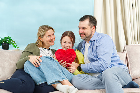有孩子的幸福家庭坐在客厅的沙发上玩得开心。