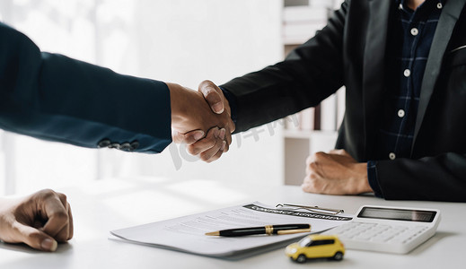 合作客户与推销员在协议后握手，成功的汽车贷款合同购买或销售新车