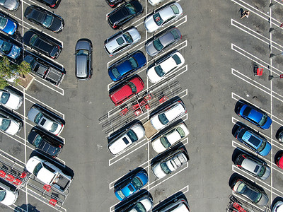 购物中心停车场的空中俯视图，有各种彩色车辆。