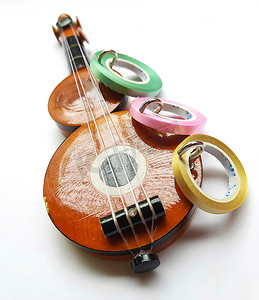 木制挂架摄影照片_印度钦奈 — 2020年7月14日：吉他形钥匙链挂架，带缎带的精美装饰在白色背景中，用于室内家居装饰