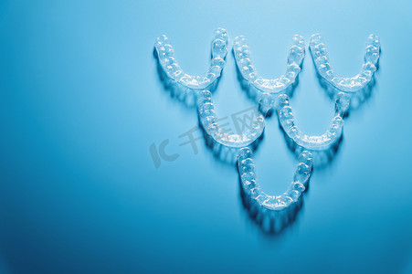 蓝色背景、牙科和牙齿矫正术中金字塔形牙齿的透明矫直器。