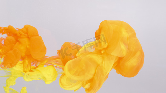 黄色液体摄影照片_溶解在水中的红色和黄色油漆滴。