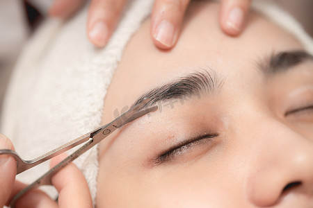 水疗沙龙的眉毛修剪服务，面部美容女性特写的面部剪发和修剪用小剪刀工具。