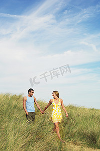 情侣牵着手摄影照片_幸福的情侣牵着手走过草地