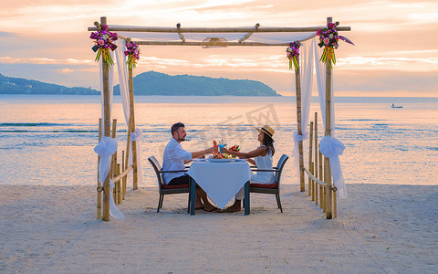 泰国普吉岛海滩上的浪漫晚餐，一对男女在海滩上共进晚餐