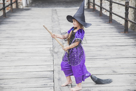 巫师城堡摄影照片_年轻的女巫正要在城堡里骑着扫帚起飞