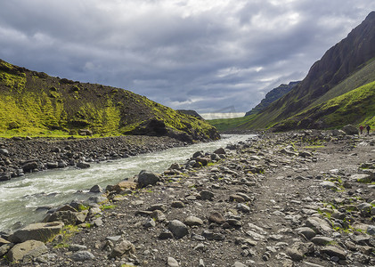 从 Laugara 河谷通往 Seljavallalaug 的小径，在冰岛南部废弃的温泉游泳池、绿色的山丘和戏剧性的天空