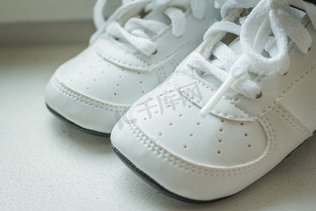 运动童鞋童鞋摄影照片_一双白色背景的白色运动鞋。婴儿运动鞋，跑步鞋。童鞋。