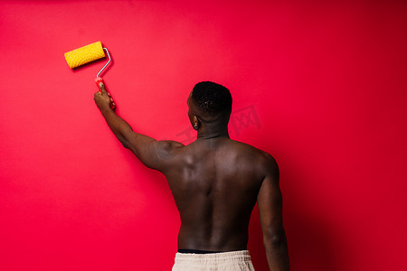 非洲画家专注于拿着专业滚筒粉刷内墙、工作室的工作。