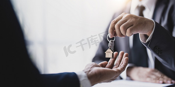 卖房经纪人拿着钥匙，样板房给客户，房地产概念。