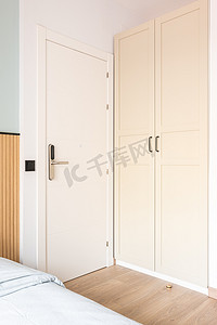 在酒店房间的衣柜和床旁边可以看到带电子数字锁的白色前门。