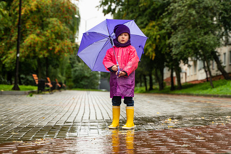 孩子在秋雨中玩耍。