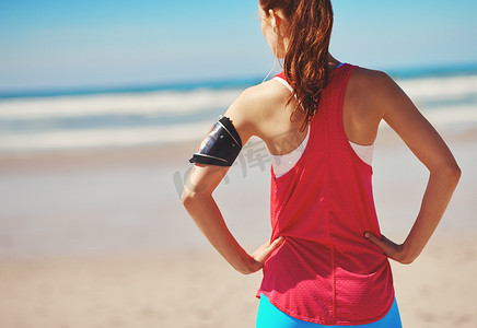 海边的海滩、健身和女运动员在跑步锻炼前看着大海的背影。
