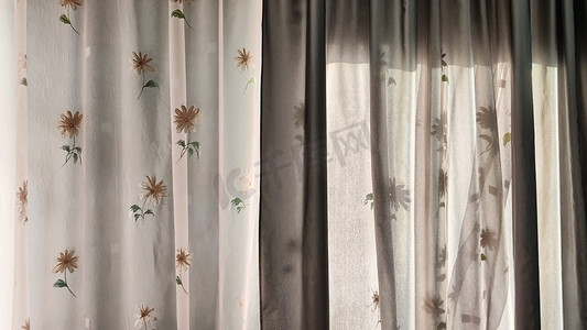 透明薄纱窗帘，窗户上有花卉图案，玻璃后面有灯光。