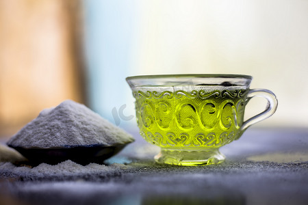 木质表面上的米粉和米粒，以及透明玻璃杯中的一些绿茶和八角茴香。用于治疗更光滑皮肤的面膜。