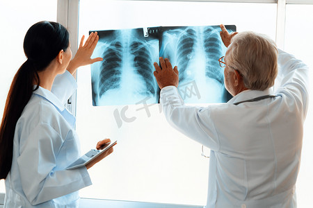 两名医生在无菌室检查 X 光片以进行医学 X 光诊断。