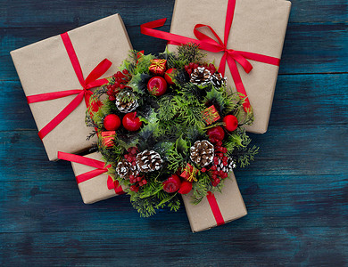 复古包装纸摄影照片_.Christmas 背景与用红丝带和装饰花环绑的礼物。