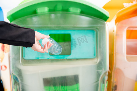 女商人将空塑料瓶水扔进回收垃圾桶
