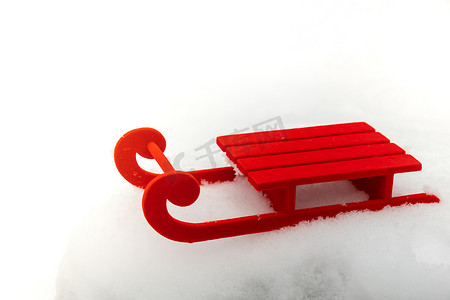 在美丽的冬日雪背景上的小红色雪橇。