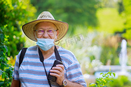公园里一位戴着医用口罩保护老人的画像