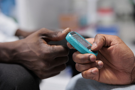 激光血糖仪摄影照片_药店的葡萄糖水平测量，非洲裔美国人的手特写