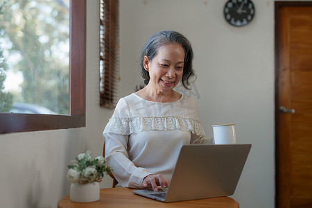 聪明的亚洲成熟中年女商人 CEO 老板领导教师使用平板电脑、电子学习、在家办公室远程在线工作