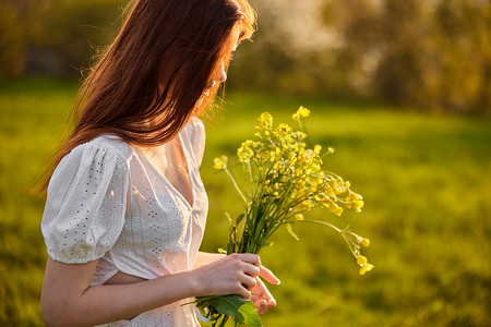 一个女人的画像，在田野里夕阳的照射下，带着一束野花