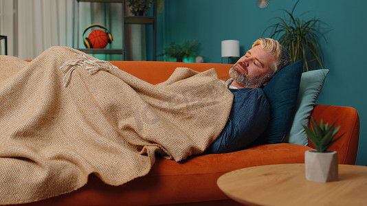 疲惫的中年成熟男人躺在床上在家休息，在沙发上打瞌睡