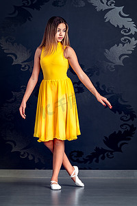 一位身穿黄色芭蕾舞裙的年轻芭蕾舞女孩的画像