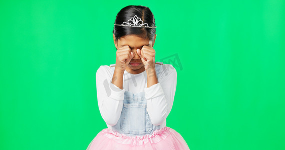 芭蕾舞皇冠摄影照片_工作室里戴着皇冠、公主服装和芭蕾舞短裙的绿色屏幕上，悲伤、沮丧和孩子在哭泣。