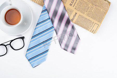 父亲节快乐背景概念，蓝色和粉色领带，白色背景的茶杯和眼镜，带有文本复制空间。