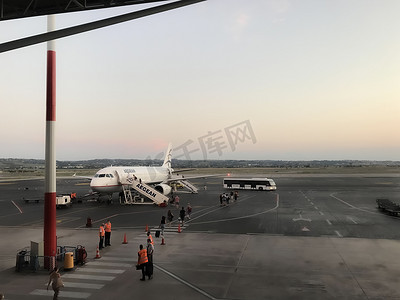 塞萨洛尼基摄影照片_希腊塞萨洛尼基 SKG 机场跑道上戴着 covid-19 防护面具的乘客。