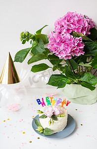 非常漂亮明亮的便当蛋糕，装饰着新鲜的洋桔梗花，背景是糖果和题词生日快乐、气球、粉红色的花朵。