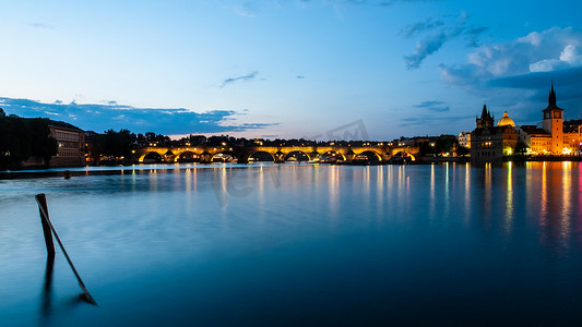 夜间在伏尔塔瓦河中反射的照明查理大桥。