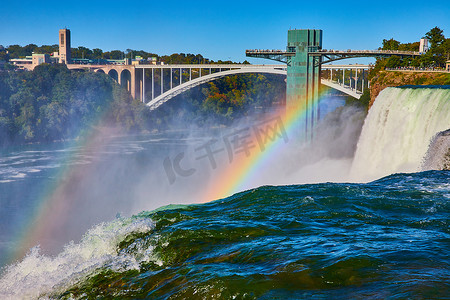 尼亚加拉大瀑布摄影照片_美国瀑布和通往加拿大的彩虹桥上的尼亚加拉大瀑布双彩虹